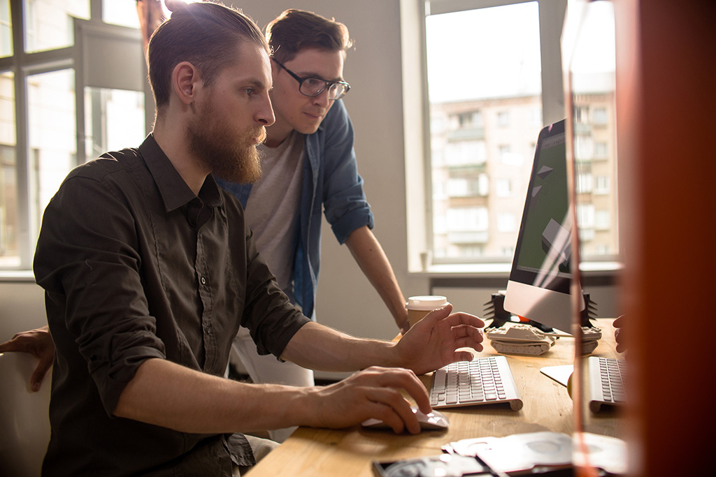 Two young men working with computer