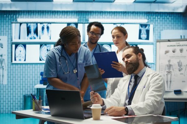 Team of medical professionals in an office on laptops